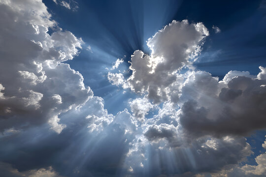 Sunlight breaking through scattered clouds on a clear blue sky during midday