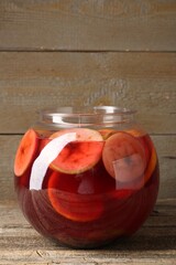 Tasty fruity punch on wooden table. Refreshing drink
