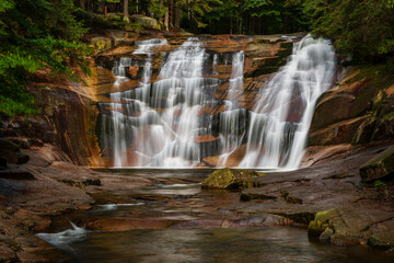 Scenic Cascade of Mumlava Waterfall Surrounded by Forest. 