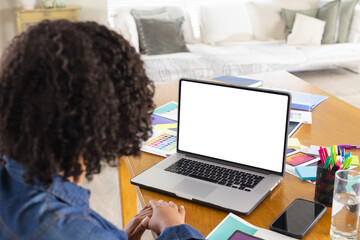 African American woman sketching color swatches on home office table with laptop, copy space