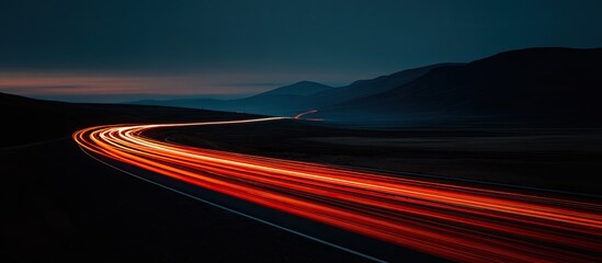 Winding road at night, illuminated by car lights