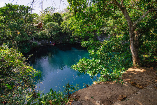 The Cenotes Laguna Dudu Located in  Duarte Province, Dominican Republic, featuring Turquoise Waters reflecting  the Surrounding Greenery, and Sky with serene and Tranquil Atmosphere
