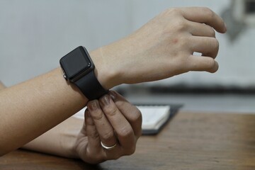 Person Adjusting Black Smartwatch On Wrist