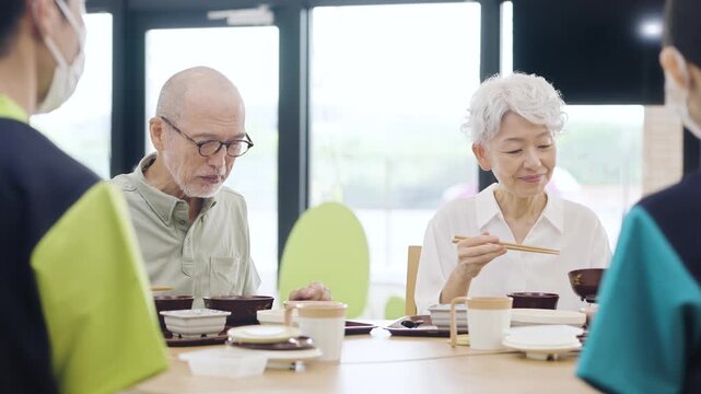 介護施設で食事をするアジア人高齢者