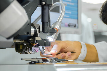 Die bonding machine in operation with skilled technician performing wire bonding process on semiconductor components