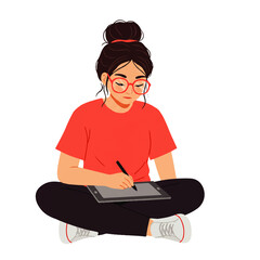 A young woman with glasses and a hair bun sits cross-legged, drawing on a digital tablet with a stylus.