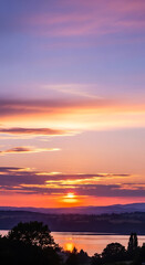 Picturesque sunset over a tranquil lake with colorful sky and silhouette trees