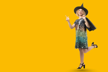 A witch joyfully gestures on Halloween on yellow background