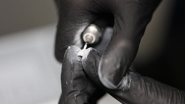 Macro view of dentist using rotary tool with fine bur to polish freshly milled veneer. Concept of cosmetic dentistry, CAD/CAM, and smile design.