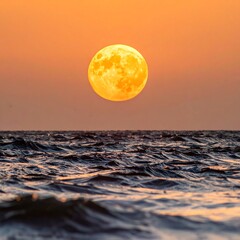 Golden moon over a tranquil ocean at sunset