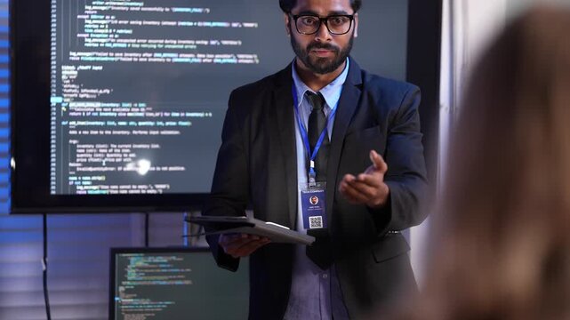A confident man gives a presentation about AI and technology. He stands in front of a big screen showing computer code, explaining his new invention to the audience at a conference.
