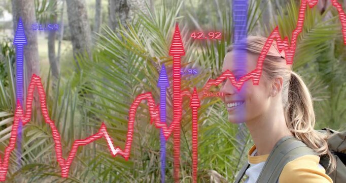 Woman wearing backpack turning in woods, data overlay fading and graphs surging around in tech