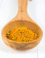 Turmeric powder in wooden spoon (1)