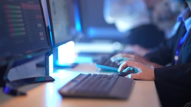 In a modern, blue-lit office, professionals' hands fly across keyboards, showcasing a high-speed digital workflow, intense data processing, and corporate workforce productivity.