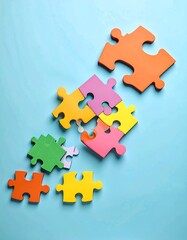 Colorful puzzle pieces scattered on a light blue background