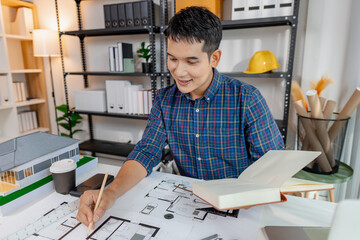 Young architect working in office with building models and floor plans, analyzing details and creating innovative design concepts, showing creativity, focus, and dedication in architecture projects.