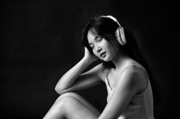 Naklejka premium young woman listening to music with headphones for audio, podcast and music for rest on weekend. Eyes closed, living room and person listening to playlist, radio or streaming subscription for wellness