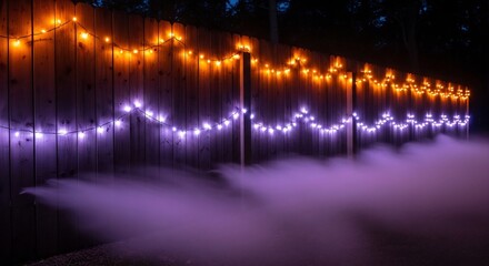 A wooden fence decorated with two strings of lights and partially obscured by fog