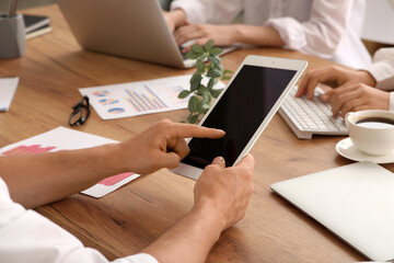 Business team working with tablet and laptop during meeting in office, closeup