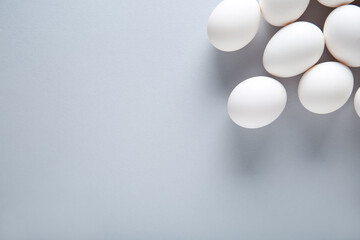 Raw chicken eggs on grey background