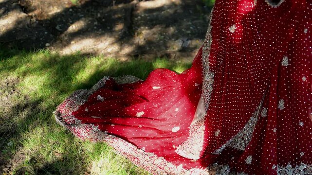 Bride in the traditional Indian wedding red dress is posing for photoshoot, Move camera view of hand. Close up view of hands 