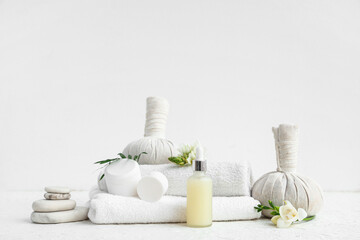 Composition with cosmetic products, spa accessories and flowers on light background