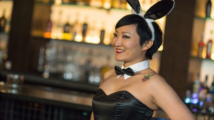 Close Up of Asian Woman in Black Bunny Girl Costume with Tattoo Behind Bar Counter