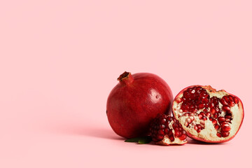 Fresh ripe pomegranates on pink background