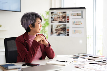 Happy dreamy mature senior architect or interior designer  woman looking away at copy space and dreaming, planning. Smiling smart older 50s lady thinking of new opportunities vision.