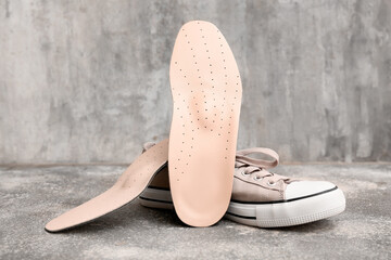 Shoe with orthopedic insoles on grey grunge background