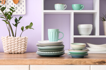 Clean plates, bowls and cup on wooden counter in kitchen, closeup