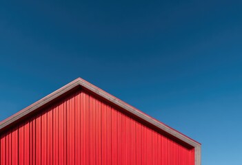 Red corrugated metal building against a vibrant blue sky