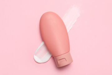 Bottle of cosmetic product and sample on pink background