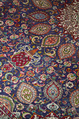 Detail of persian carpet macro: floral blue and red pattern texture
