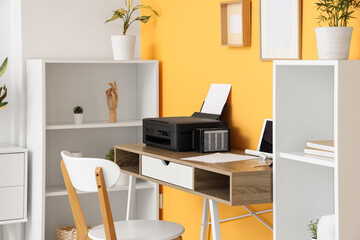 Workplace with modern printer and laptop in stylish home office