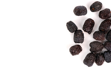 A small group of dry, dark dates is placed on the right side of a white background.
