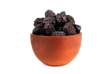 A brown wooden bowl is filled with a pile of dark, dry dates.