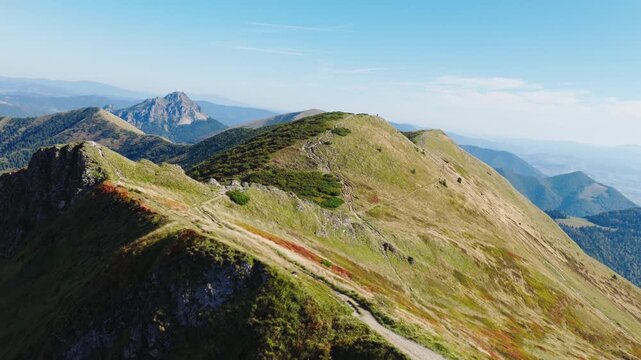 Breathtaking drone footage over Chleb peak in the Mal&aacute; Fatra mountains, Slovakia, showing scenic ridges, hiking trails, and panoramic views of untouched nature under a clear blue sky.