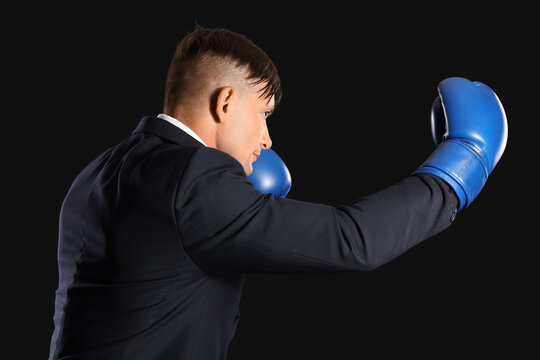Male boxer in suit on dark background