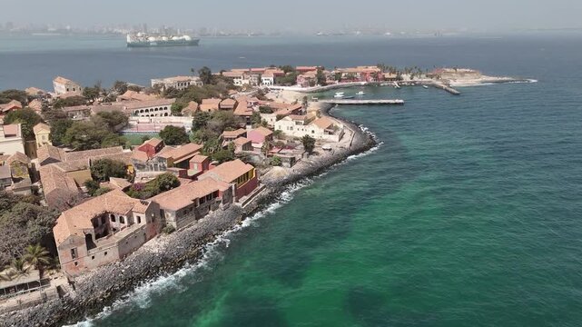 Wide drone aerial of Gor&eacute;e Island coastline in Senegal, showing colonial architecture, historic heritage and vibrant turquoise waters of the Atlantic