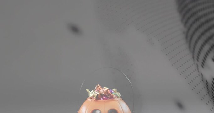 View shifting revealing pumpkin bucket spilling candies via rotating dot mesh showcasing treats