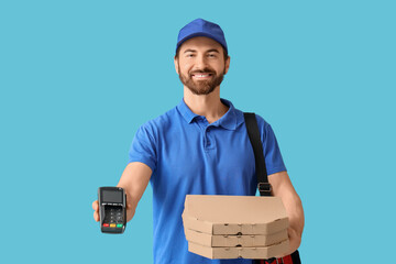 Male courier with pizza boxes and payment terminal on blue background