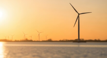 Wind turbines in the water at sunset with orange sky and a field of turbines in the background view