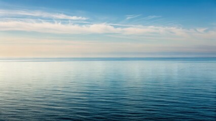 Obraz premium Calm seascape with gentle waves reflecting a serene sky and distant horizon, creating a peaceful atmosphere.