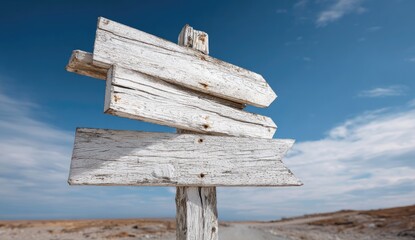 Aged wooden directional sign against a clear sky