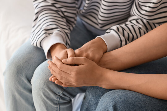 Young woman supporting her friend with suicidal thoughts in bedroom, closeup