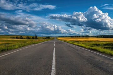 Empty road stretching into a vibrant landscape under a partly cloudy sky