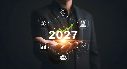 A person holding the year twenty twenty seven with growth icons surrounding on a dark background