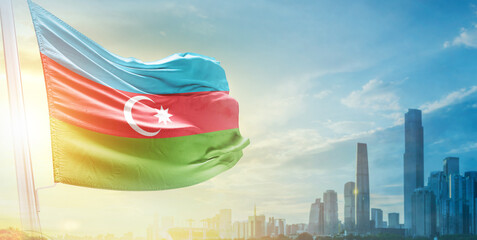 Azerbaijan flag wavering in beautiful clouds with building skyline. The flag with drone shot in beautiful sky. Azerbaijan national flag for independence day.