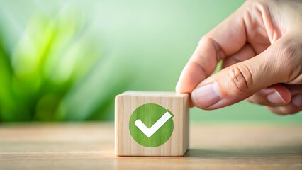 Hand placing wooden block with check mark symbol on a wooden surface